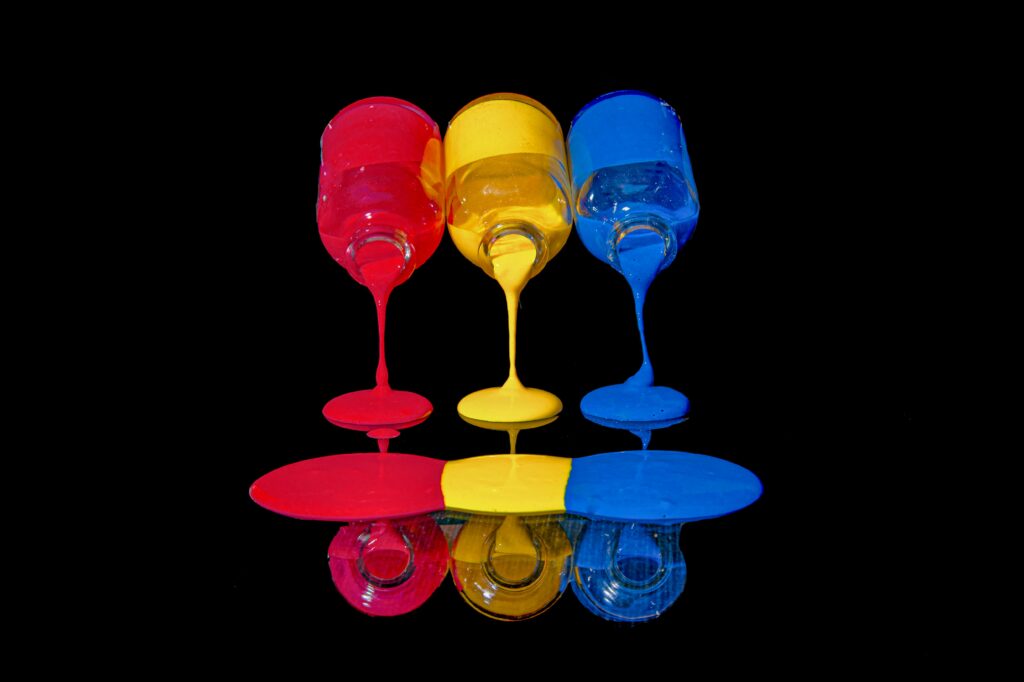 Red, Yellow, Blue acrylic paints pouring onto surface.