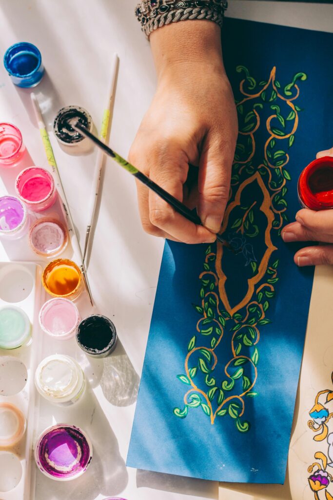 Painter adding acylic paint to the canvas.